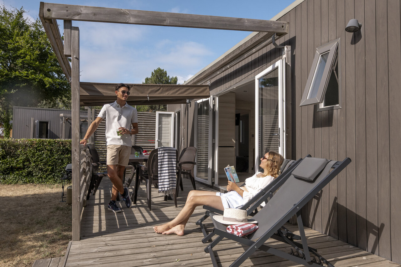 Mobile home moderne avec terrasse, couple relaxant au camping CLICOCHIC Chouans � SAINT HILAIRE DE RIEZ.