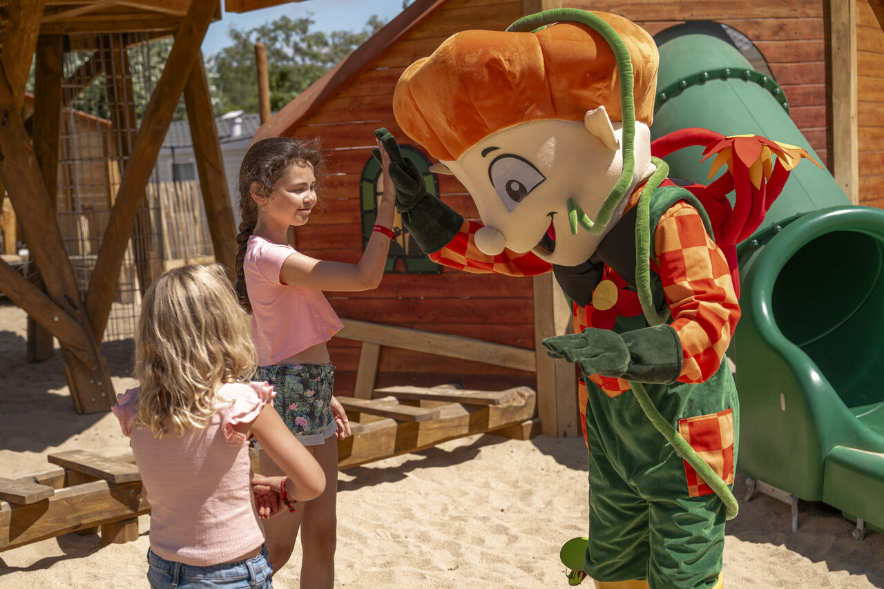 Mascotte et enfants sur l'aire de jeux au camping CLICOCHIC Chouans (85).