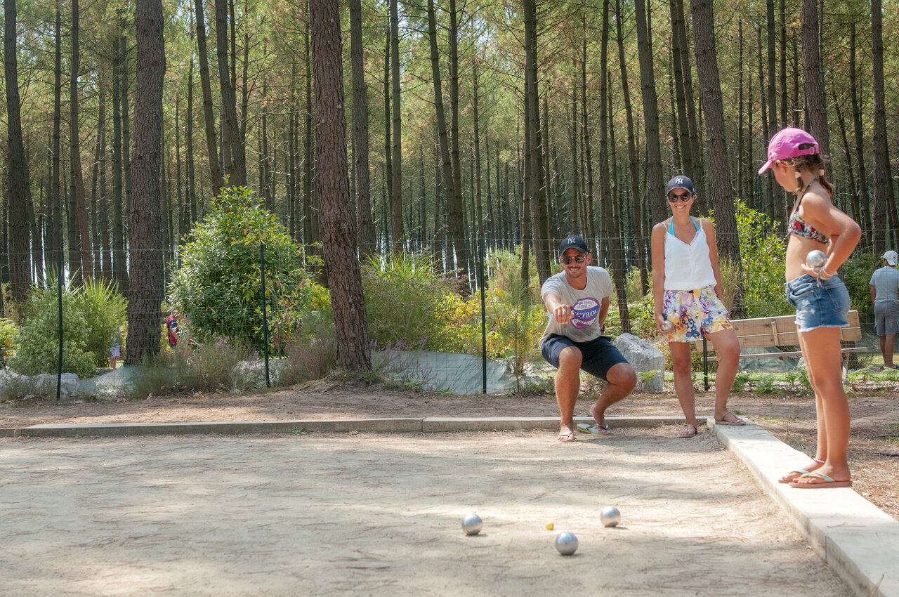 Famille jouant � la p�tanque sur terrain ombrag� au camping VAGUES OCEANES Les Cigales � Moliets-Plage (40).