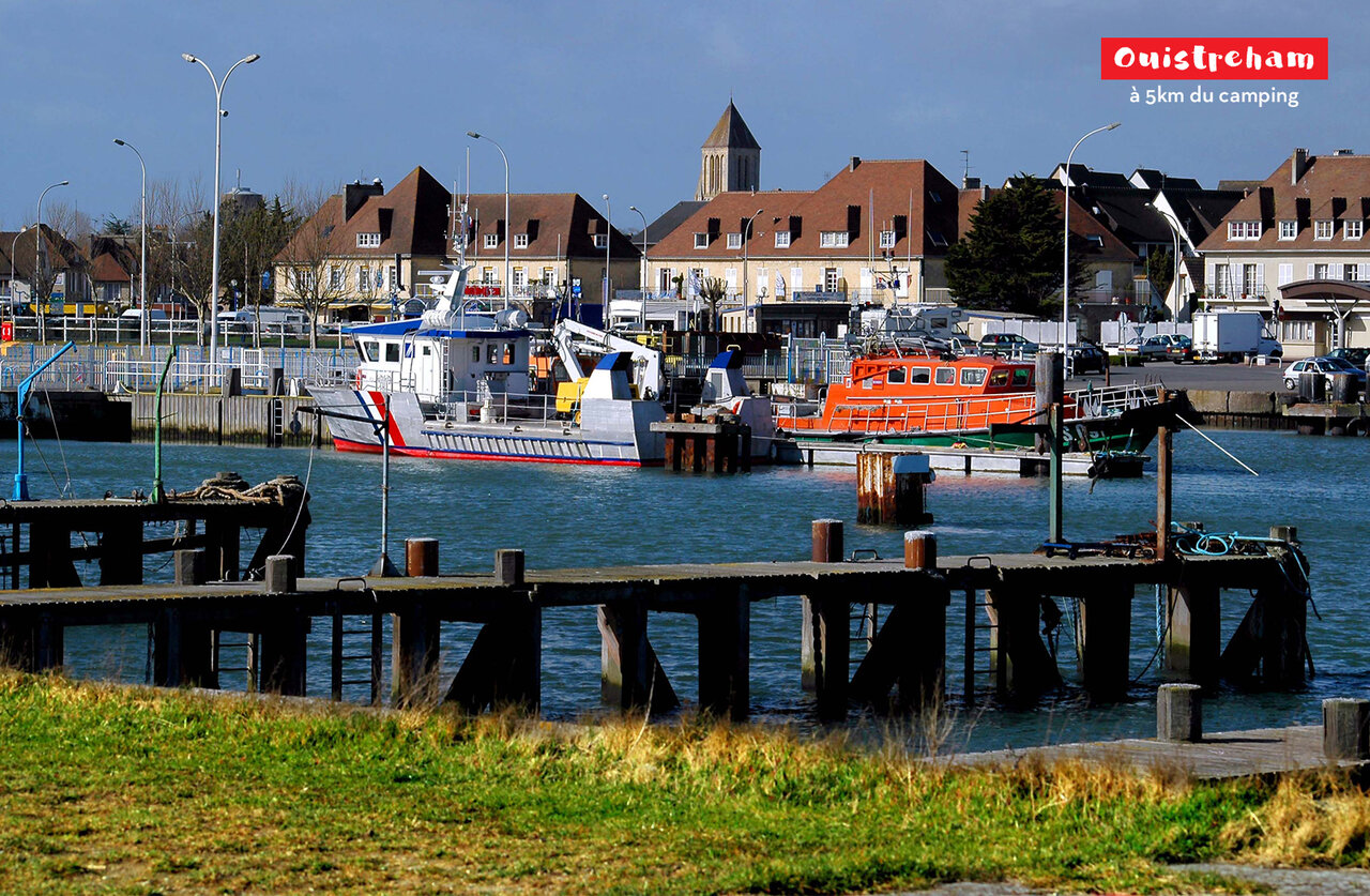 Port de Ouistreham avec bateaux de sauvetage et b�timents historiques en Normandie.