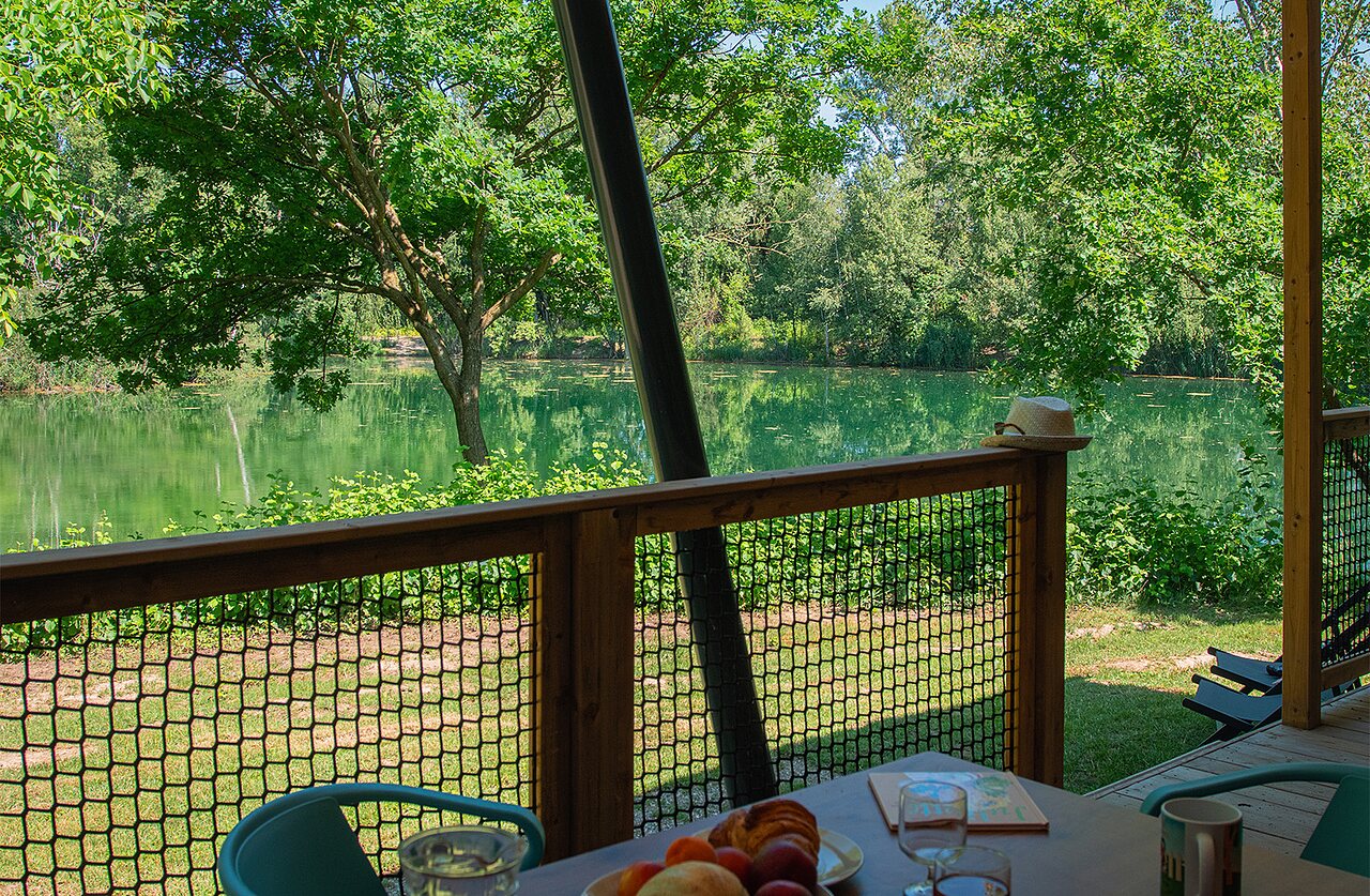 Terrasse d'h�bergement avec vue sur lac au camping CLICOCHIC Au Clair Ruisseau � Gerstheim.