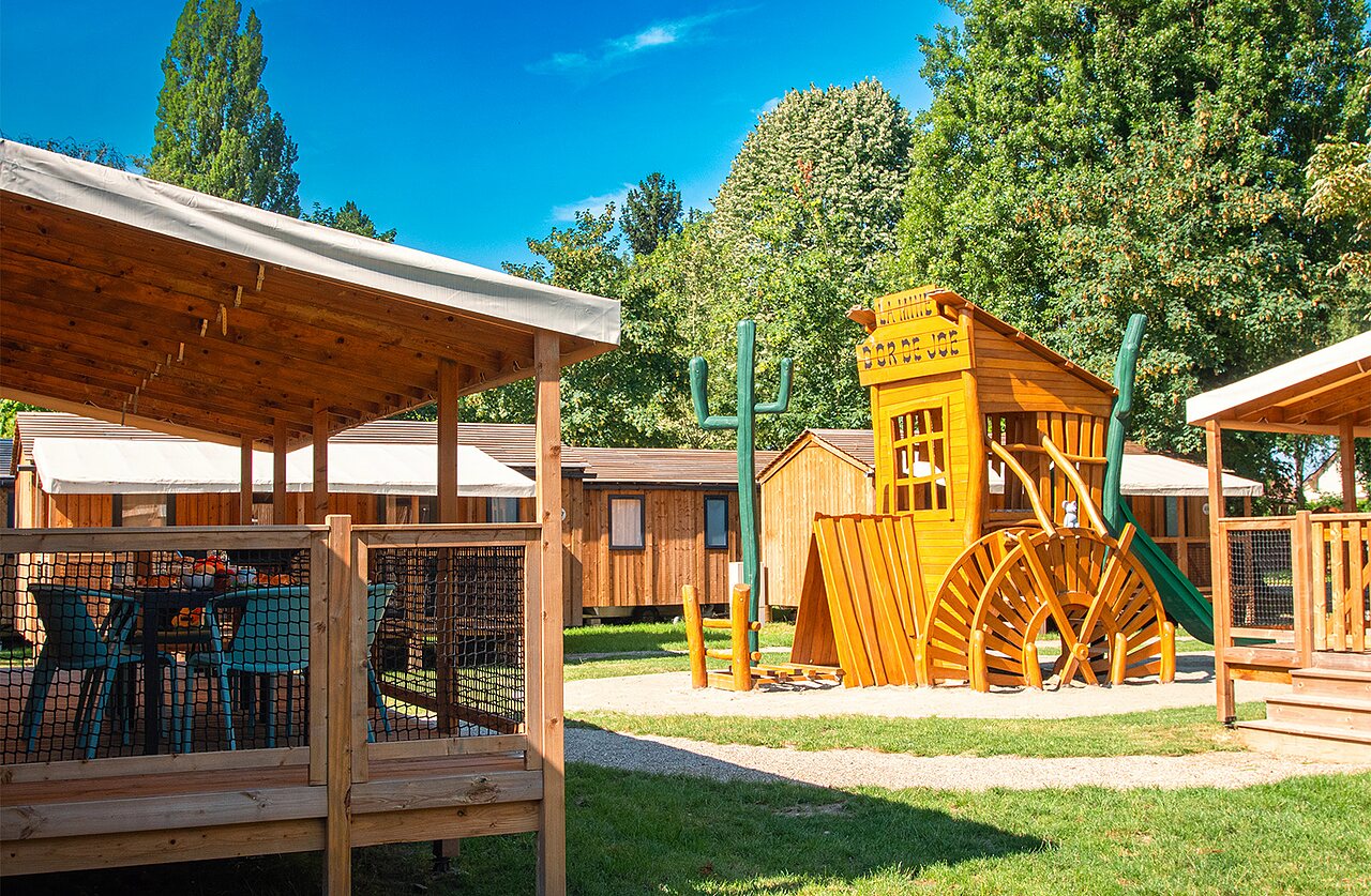 Aire de jeux western et terrasse d'h�bergement au camping CLICOCHIC � Gerstheim (67).