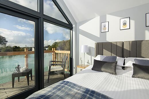Chambre moderne, lit double, terrasse lacustre au camping CAPFUN UK Clawford Lakes.