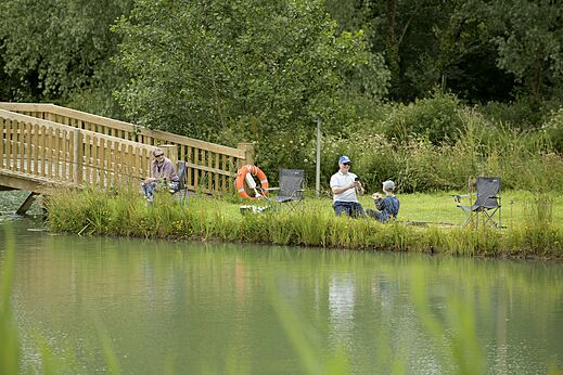 Pêche au lac avec pont en bois au camping CAPFUN UK Clawford Lakes, Clawton.