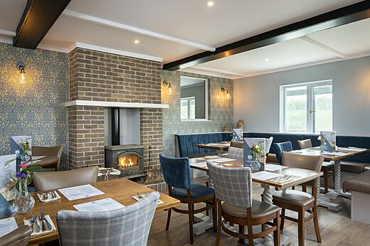 Restaurant intérieur avec cheminée et tables au CAPFUN UK Clawford Lakes à Clawton, Holsworthy.