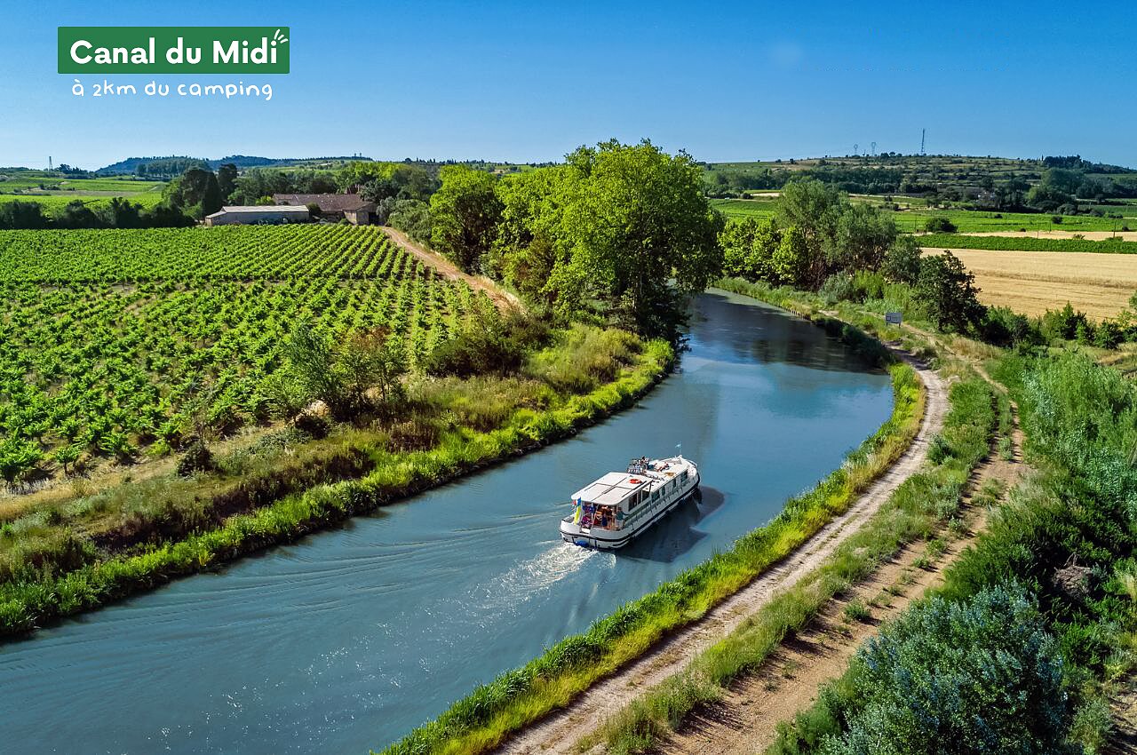 Bateau naviguant sur le Canal du Midi, entour� de vignobles, pr�s de Rustiques (11).