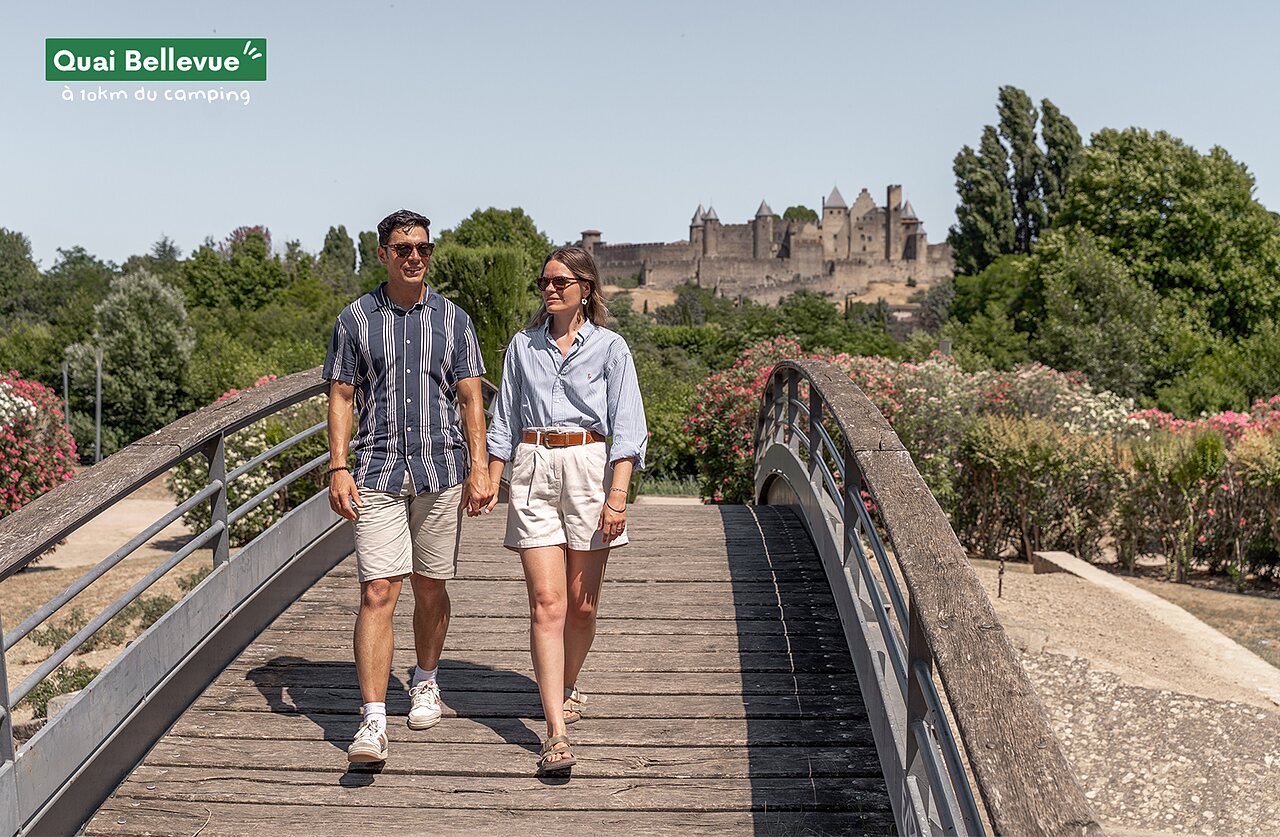 Couple visitant la cit� m�di�vale de Carcassonne depuis un pont fleuri.