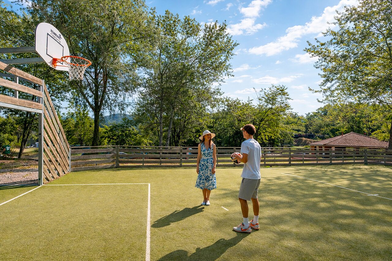 Terrain multisport avec panier de basket et couple au camping CLICOCHIC Couriou � Recoubeau-Jansac (26).