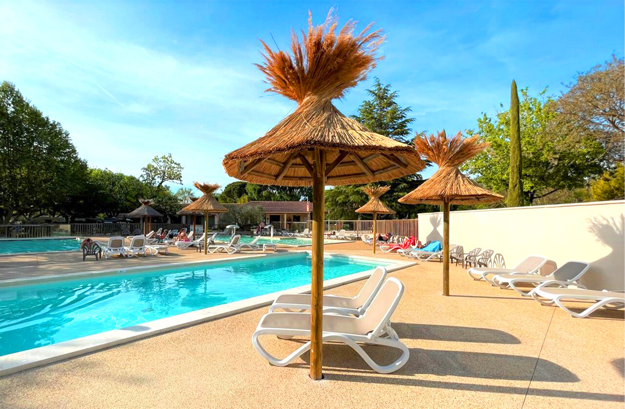 Piscine ext�rieure, transats et parasols au camping CLICOCHIC Couteli�re � Lagnes (84).