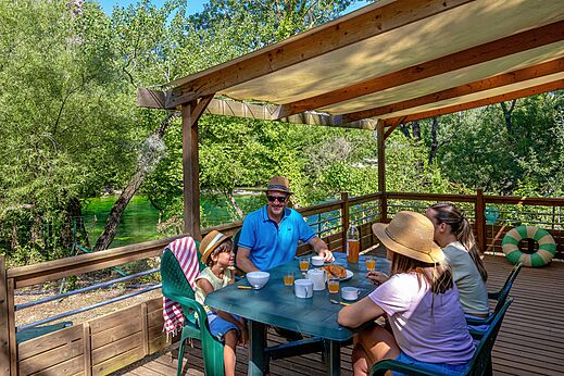 Famille déjeunant terrasse Mobil-home vue rivière au camping CLICOCHIC Coutelière à Lagnes.