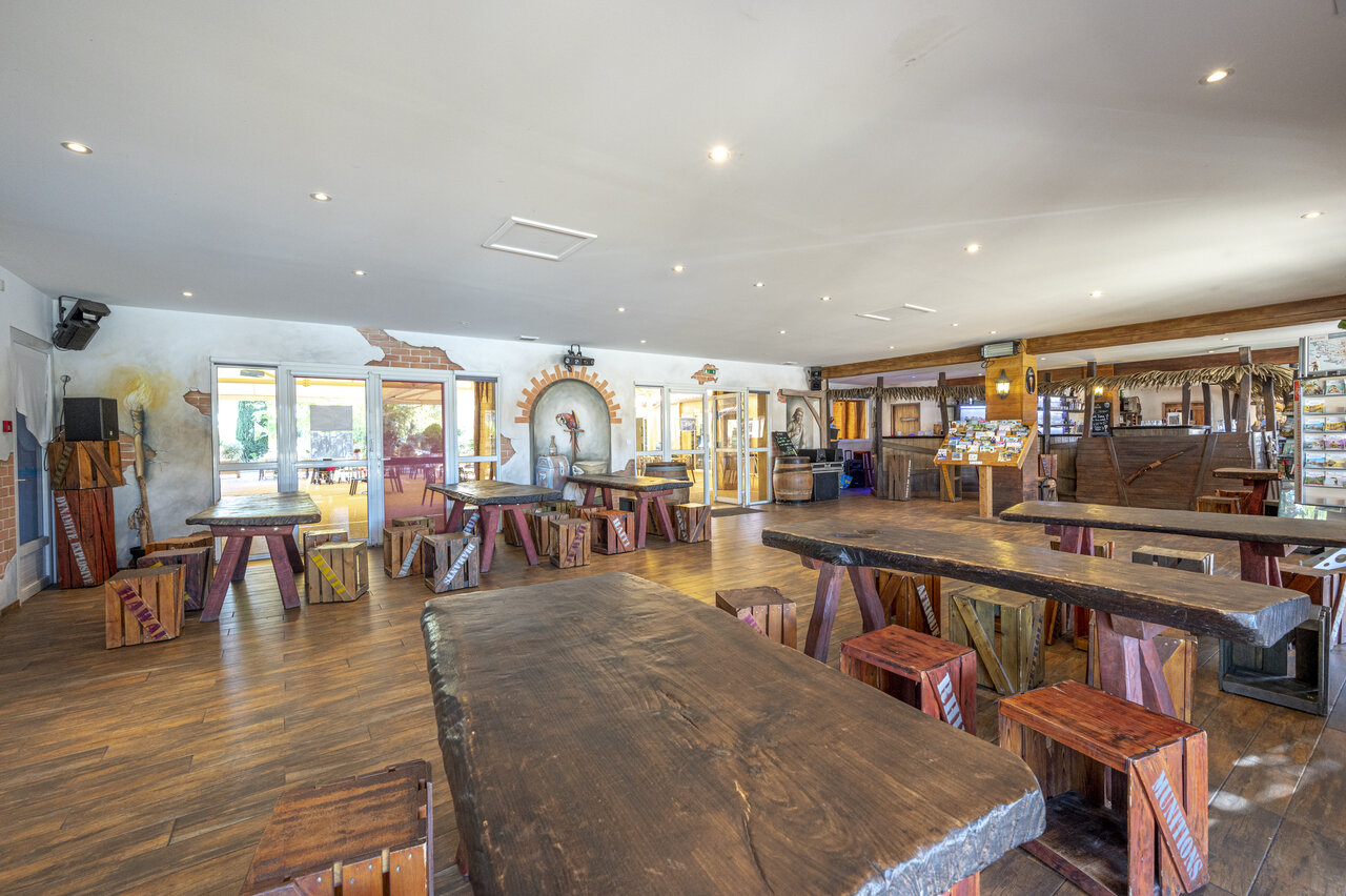 Bar et restaurant th�matique avec grandes tables en bois au camping CAPFUN Dauphins Bleus � GIVRAND (85).
