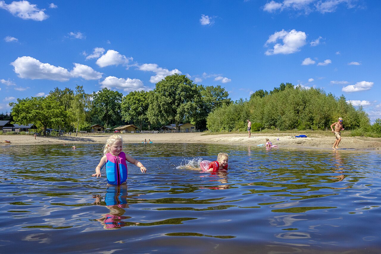 Enfants jouant dans le lac et sur la plage au camping CAPFUN De Belten � Rheeze.