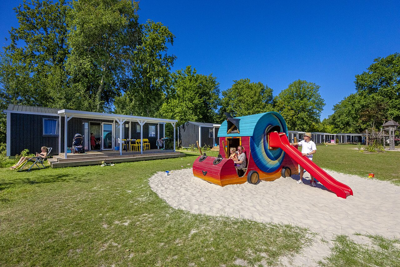 Aire de jeux color�e avec toboggan et mobile homes au camping CAPFUN De Belten � Rheeze.