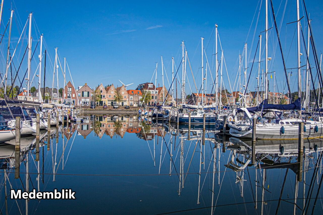 Port de plaisance historique de Medemblik avec voiliers et maisons traditionnelles hollandaises.