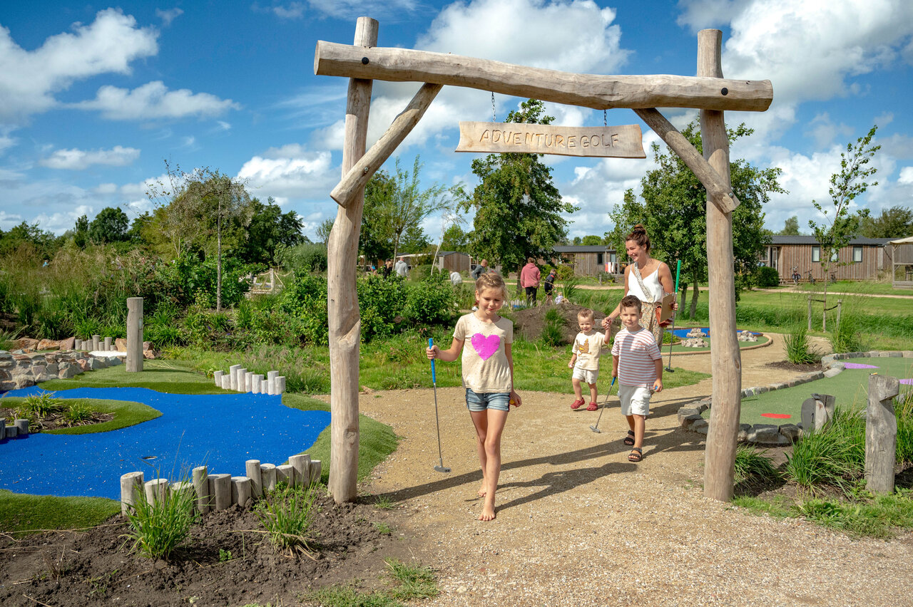 Famille jouant au mini-golf aventure sur un parcours ludique au camping CAPFUN De Bongerd � Tuitjenhorn.