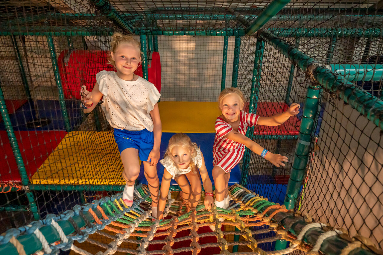 Aire de jeux int�rieure avec enfants souriants au camping CAPFUN De Bongerd � Tuitjenhorn.