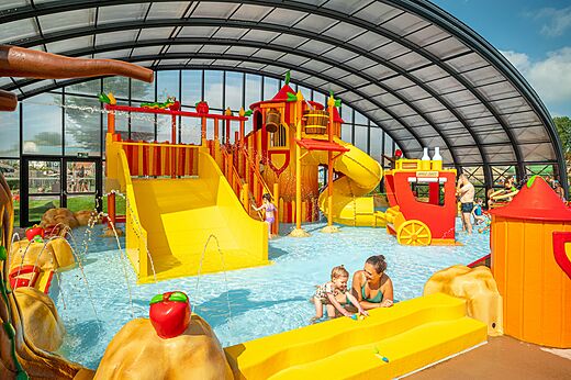 Aire de jeux aquatique couverte avec toboggans et enfants au camping CAPFUN De Bongerd � Tuitjenhorn.