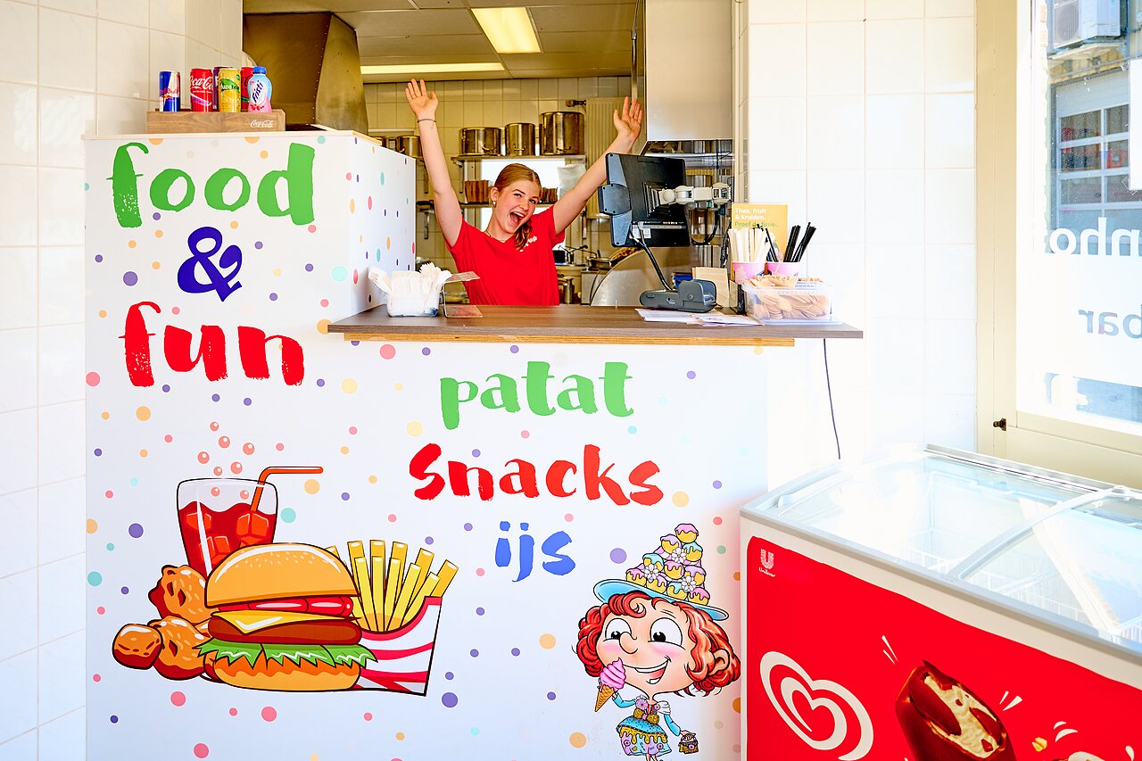 Comptoir de snack-bar color� avec employ�e souriante, frites et glaces au camping CAPFUN De Eikenhof � Paasloo/Oldemarkt.