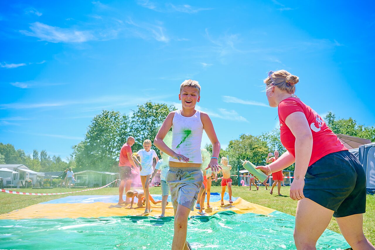 Enfants et animateur sur toboggan aquatique color� au camping CAPFUN De Eikenhof.