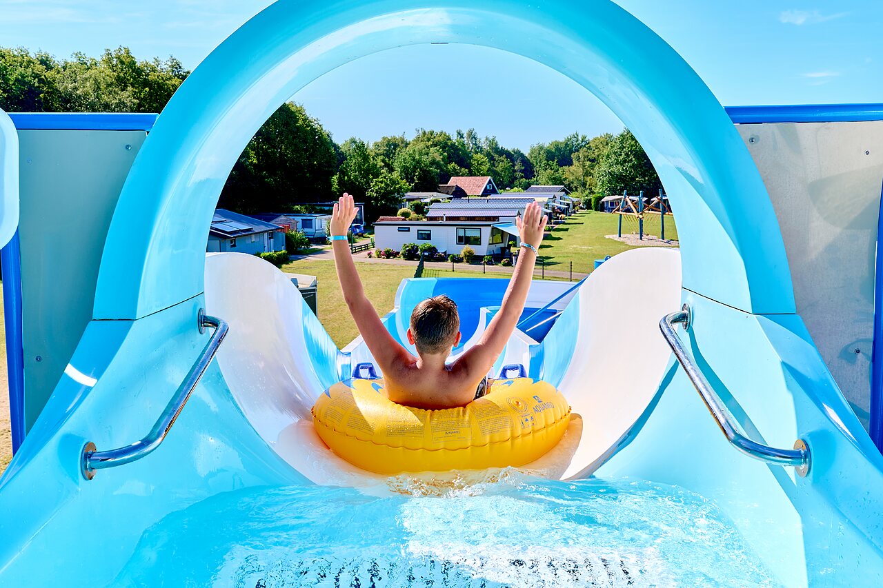 Enfant sur toboggan aquatique, bou�e jaune, au camping CAPFUN De Eikenhof � Paasloo/Oldemarkt.