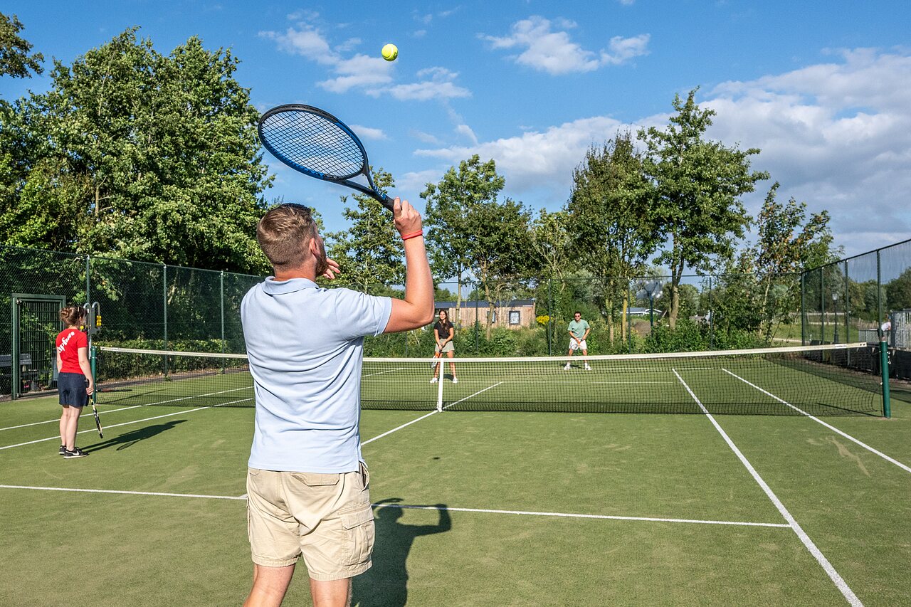 Joueurs de tennis sur un court ext�rieur ensoleill� au camping CAPFUN De Pekelinge � Oostkapelle.
