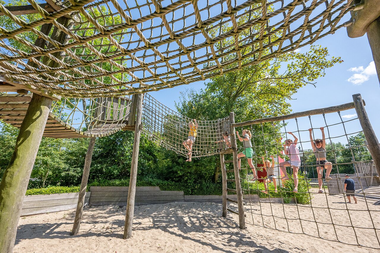 Enfants grimpant sur structure de jeux en cordes et bois au camping CAPFUN De Pekelinge � Oostkapelle.