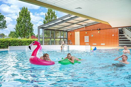 Piscine couverte et découverte avec famille et jeux gonflables au camping CAPFUN De Pekelinge à Oostkapelle.