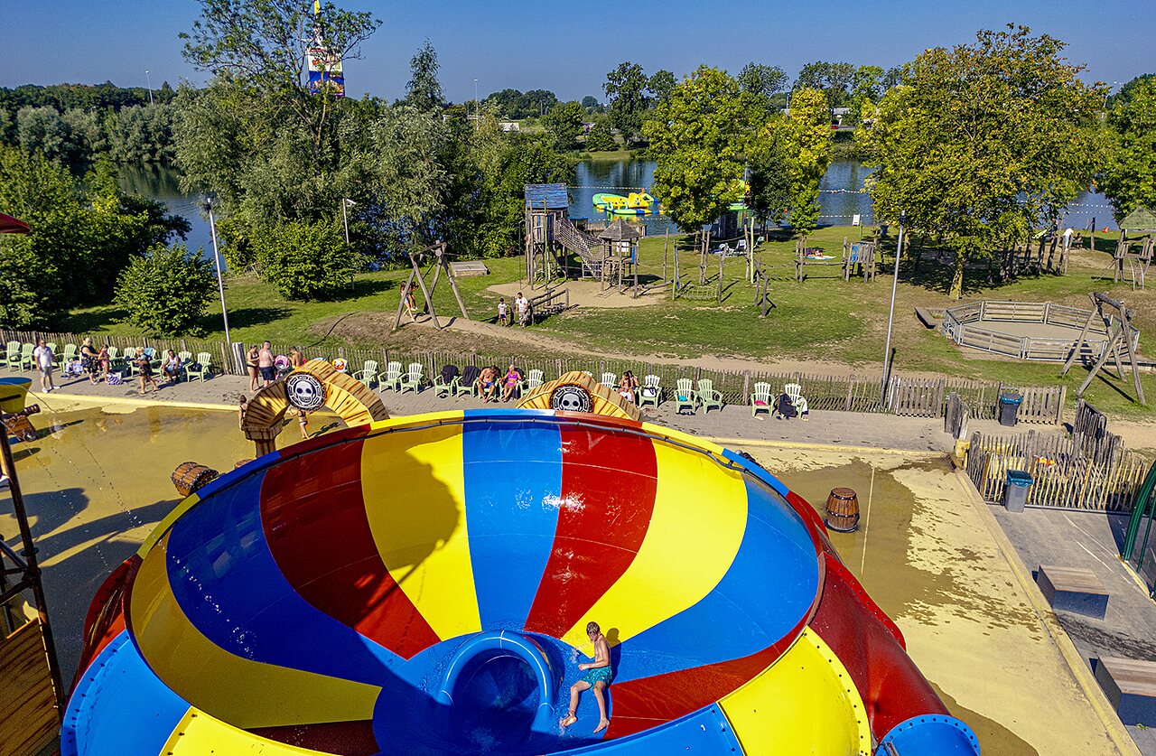 Toboggans aquatiques et piscine avec enfants rieurs au camping CAPFUN De Rotonde � Enspijk.