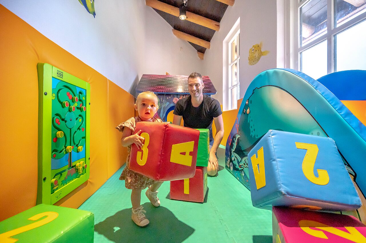 Aire de jeux int�rieure avec b�b� et adulte au camping CAPFUN De Scheepsbel � Doornspijk.