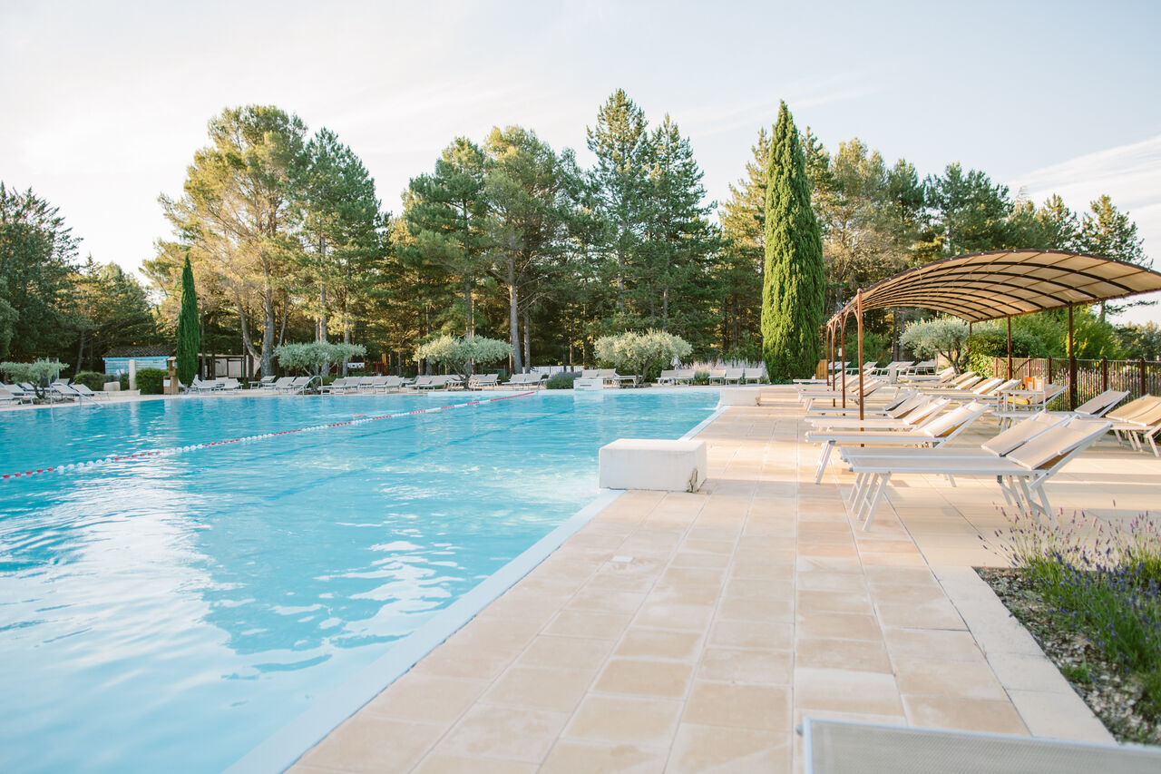 Grande piscine ext�rieure avec transats et zone ombrag�e au camping LIBRANOO Naturiste Belezy � B�doin (84).