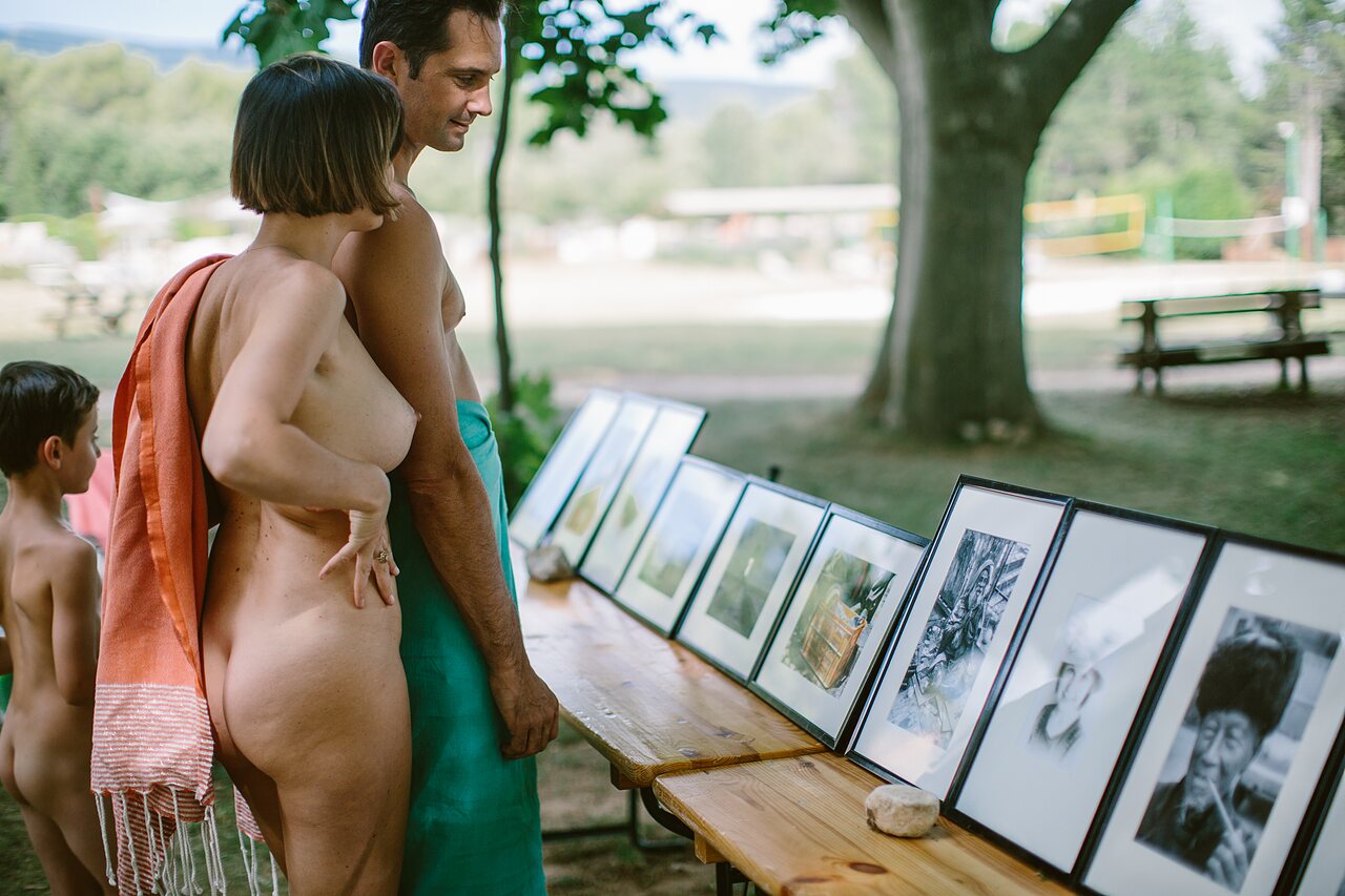 Famille naturiste regardant exposition photos au camping LIBRANOO Naturiste Belezy � B�doin.