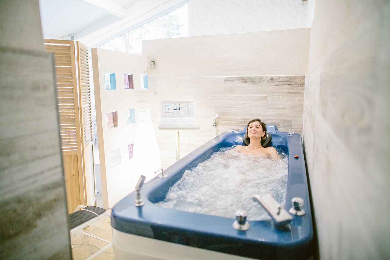 Femme relaxant dans une baignoire d'hydroth�rapie au camping LIBRANOO Naturiste Belezy � B�doin (84).