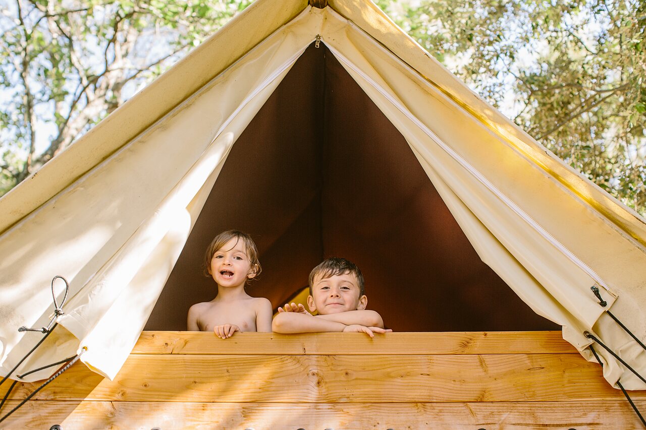 Enfants souriants dans une tente glamping en bois au camping LIBRANOO Naturiste Belezy � B�doin (84).