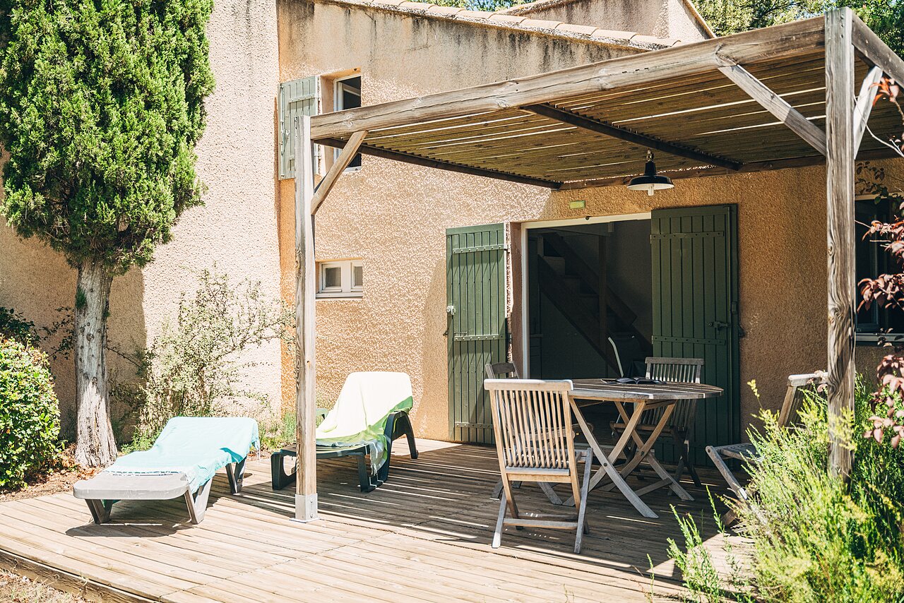 Terrasse en bois ombrag�e d'un h�bergement au camping LIBRANOO Naturiste Belezy � B�doin (84).