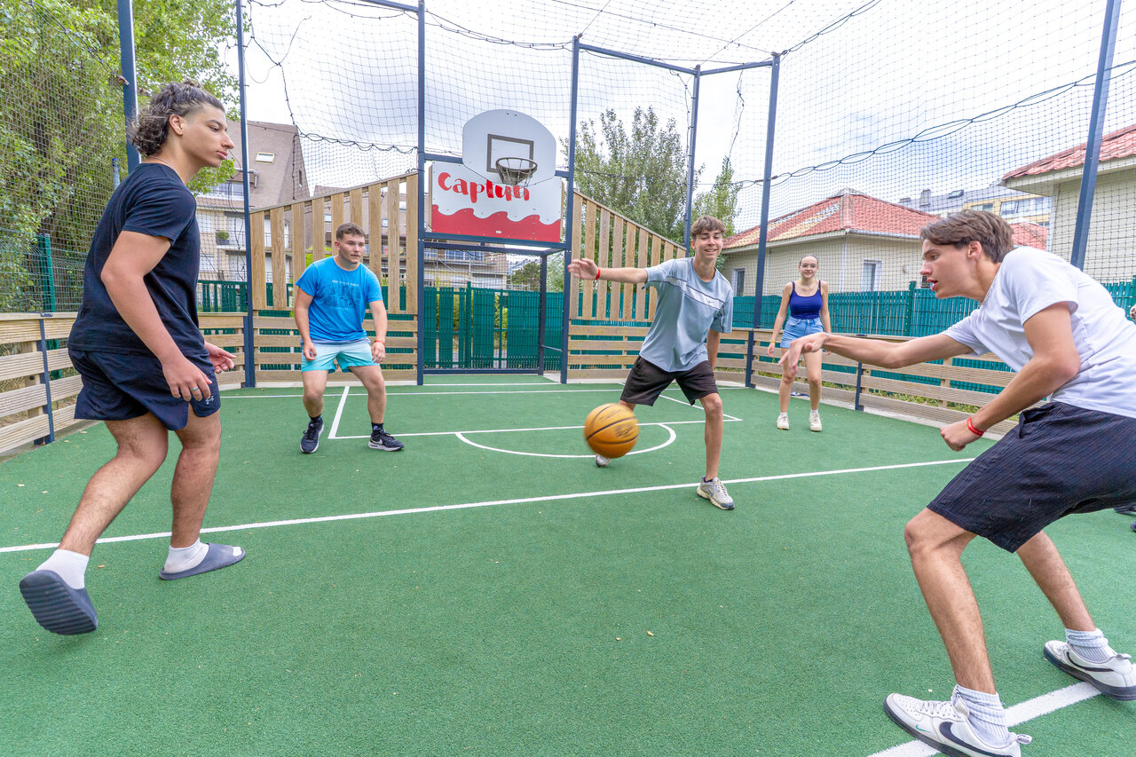 Terrain multisport, jeunes jouant au basketball au camping CAPFUN Donjon de Lars (14).