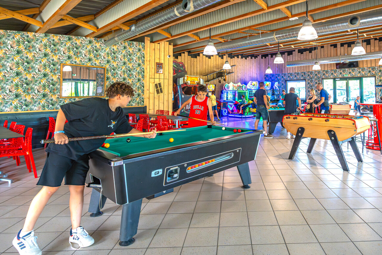Adolescents jouant au billard et jeux d'arcade au camping CAPFUN Dune Fleurie � Quend Plage.