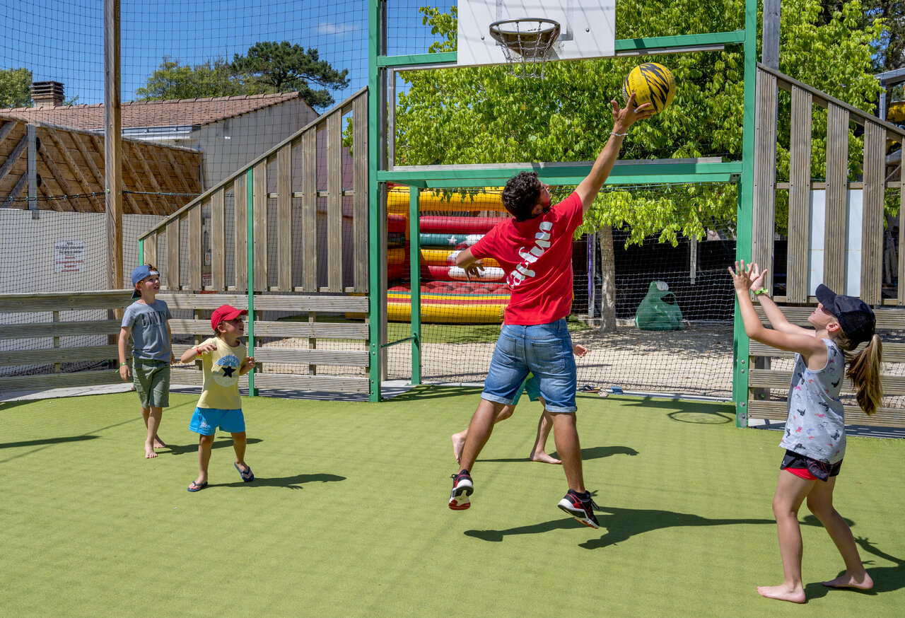 Animateur et enfants jouent basket sur terrain multisport CAPFUN Ecureuils JARD SUR MER (85).