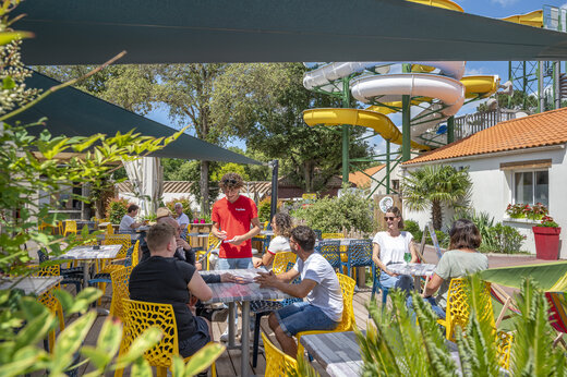 Terrasse de restaurant anim�e avec clients et serveur au camping CAPFUN Ecureuils � JARD SUR MER (85).