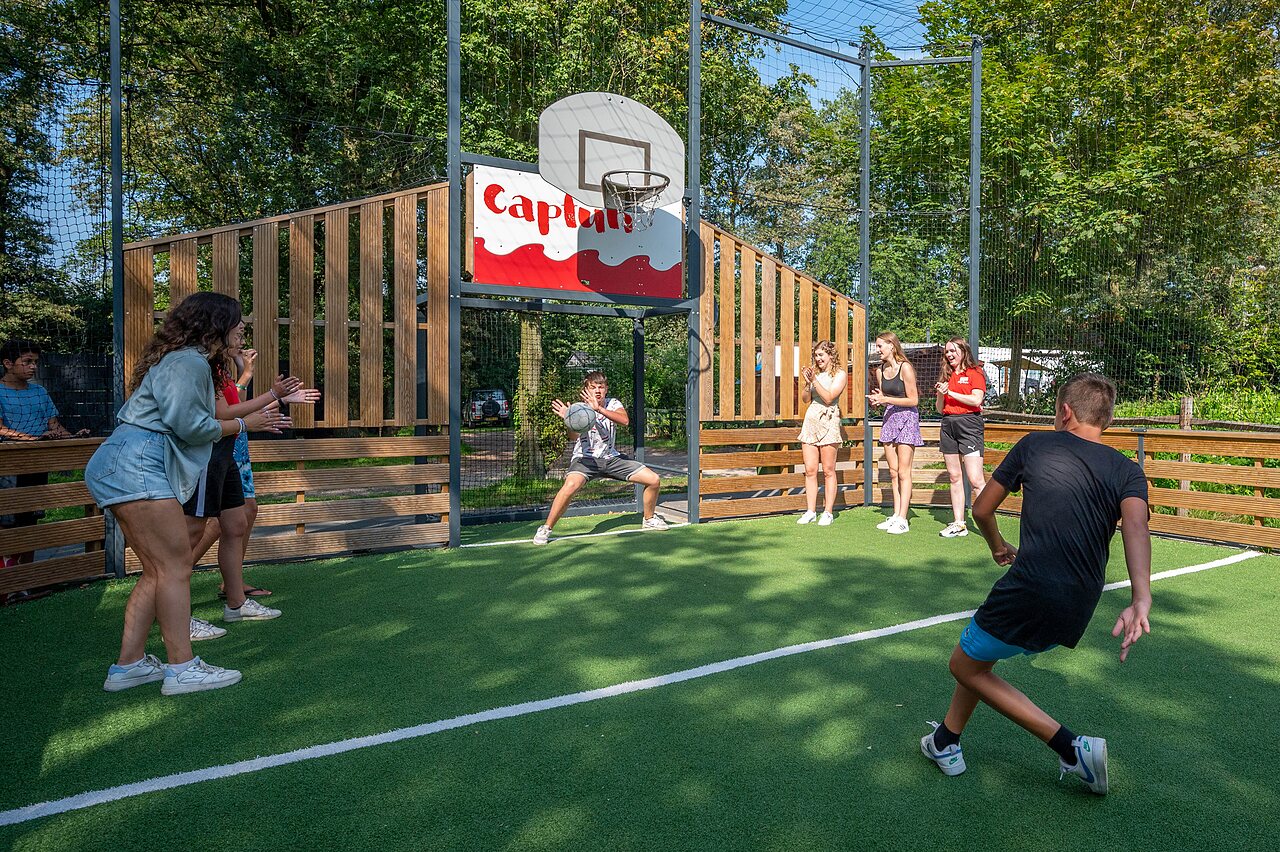 Jeunes jouant au basketball sur terrain multisport Capfun au camping CAPFUN Eibernest � Eibergen.