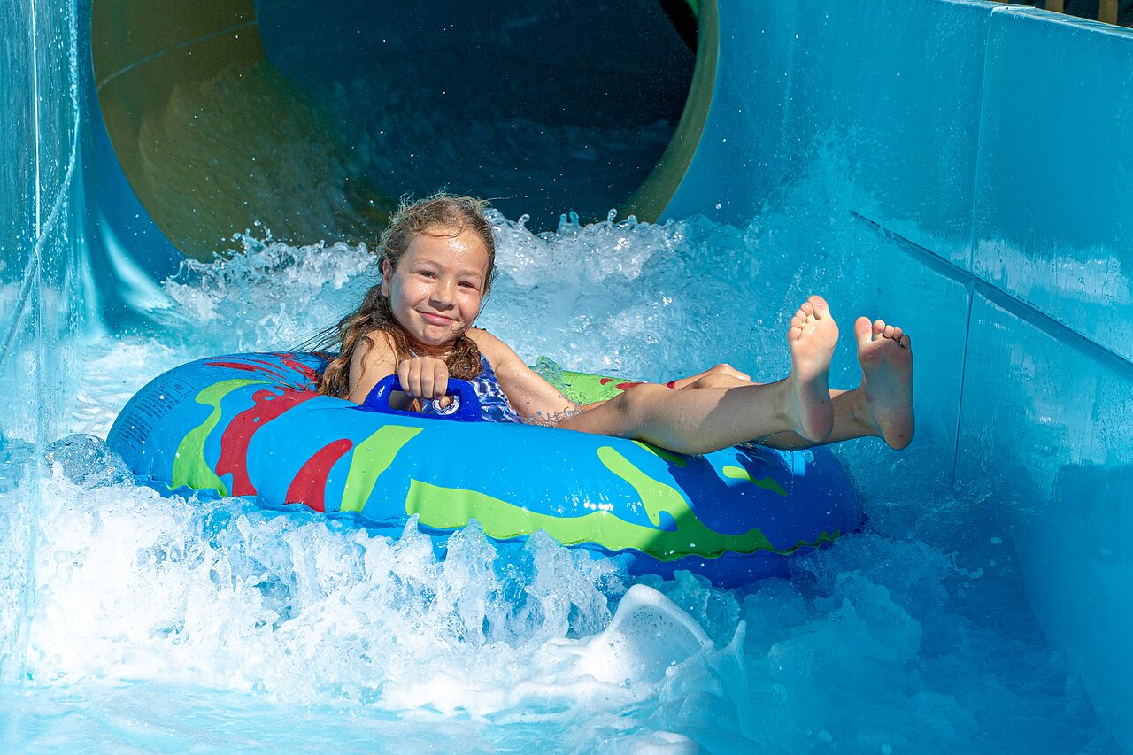 Fille sur bou�e, toboggan aquatique au camping VAGUES OCEANES Elys�e, Le Grau du Roi.