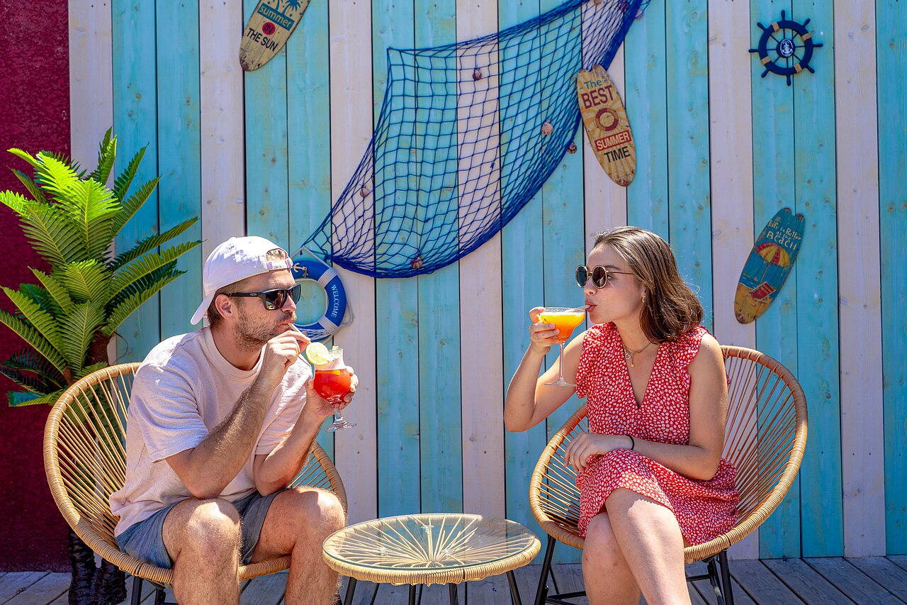 Couple d�gustant des cocktails au bar ext�rieur d�cor� au camping VAGUES OCEANES Elys�e � Le Grau du Roi (30).