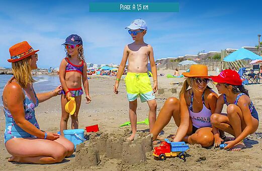 Famille avec enfants jouant sur la plage de sable au camping VAGUES OCEANES Elys�e � Le Grau du Roi (30).
