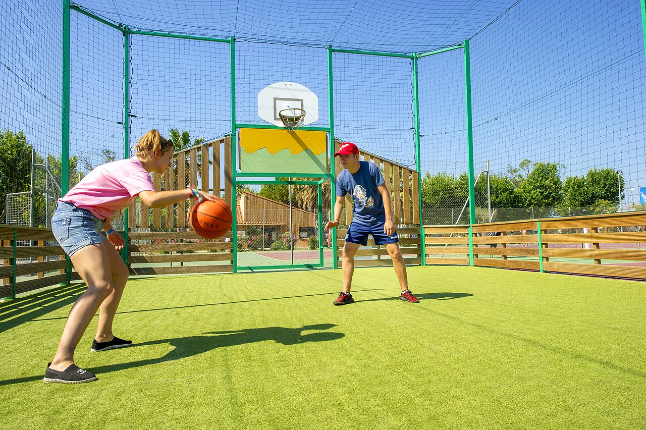Jeunes jouant au basketball sur terrain multisport au camping CAPFUN El Moli � Elne (66).