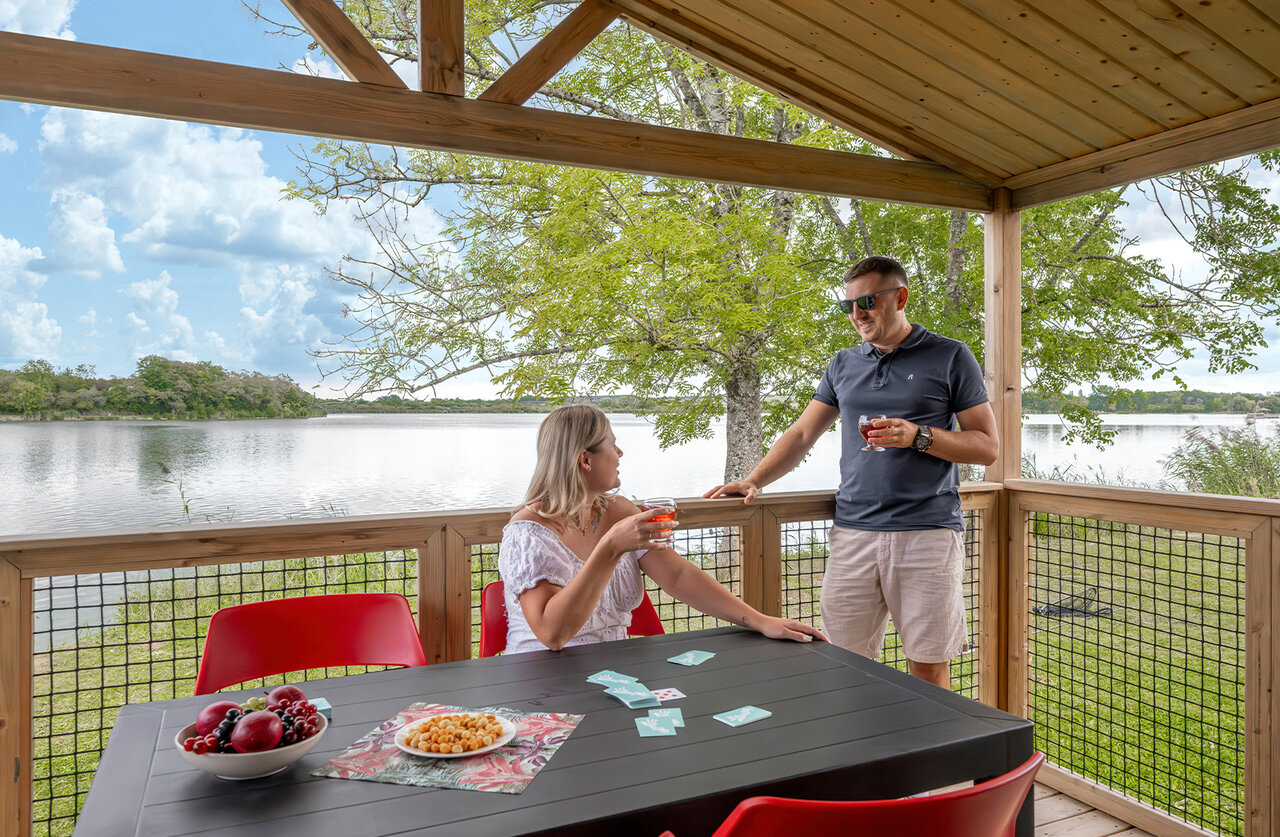 Terrasse d'h�bergement, couple et vue lac au camping CLICOCHIC Etang de la Mutche � HARPRICH (57).