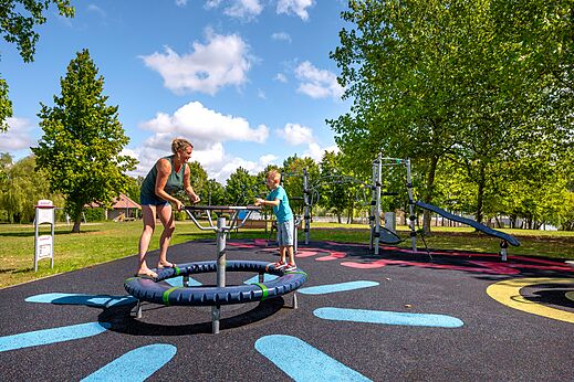 Aire de jeux moderne avec femme et enfant au camping CLICOCHIC Etang de la Mutche à HARPRICH (57).