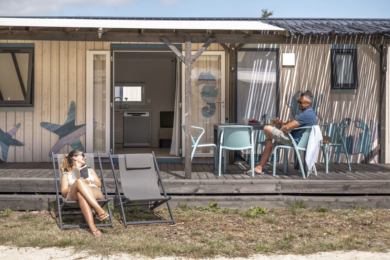 Couple relaxant sur la terrasse d'un mobile-home au camping CLICOCHIC Etoile de Mer � Asserac (44).