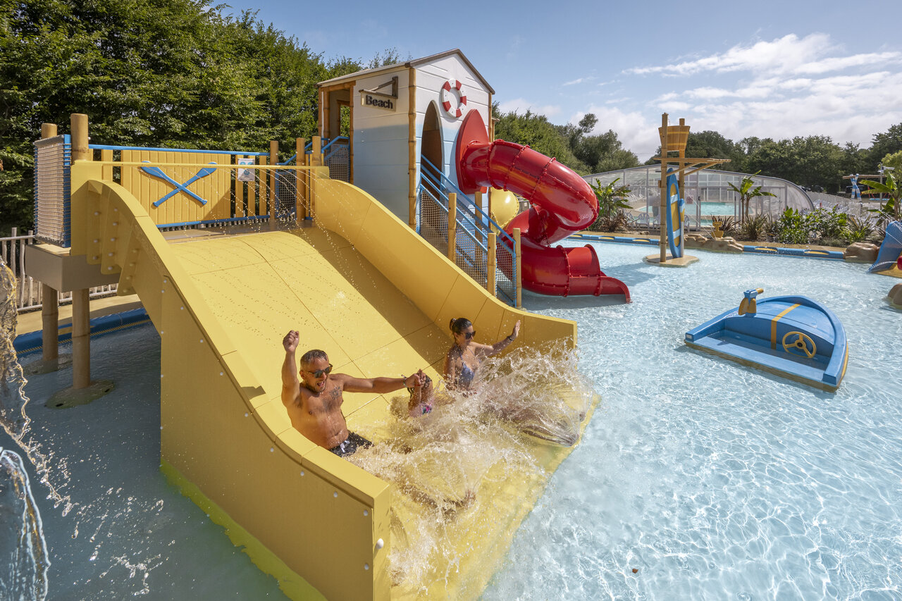 Famille s'amusant sur le toboggan aquatique jaune et rouge au camping CLICOCHIC Etoile de Mer � Asserac (44).