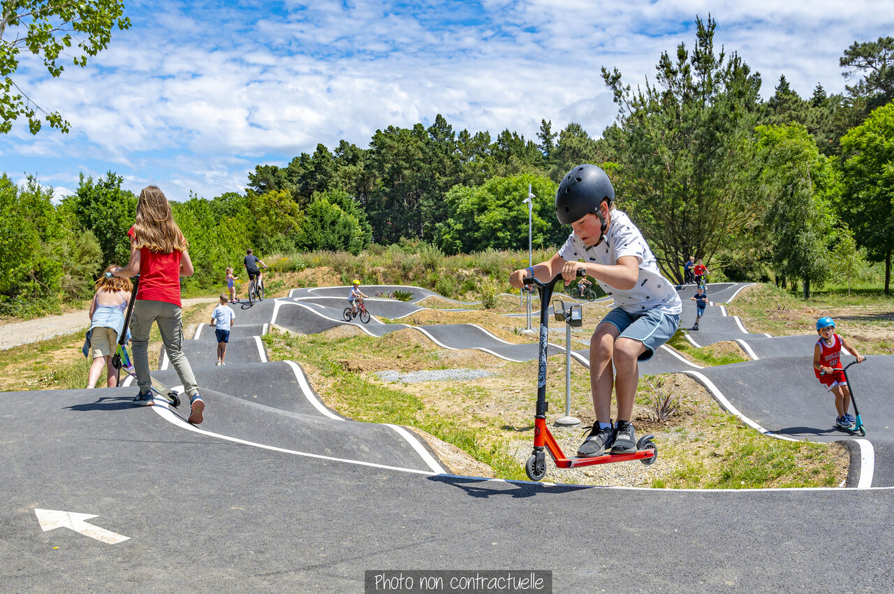 Piste de pumptrack avec enfants en trottinette et v�lo au camping CAPFUN Falaises � Gonneville sur Mer.