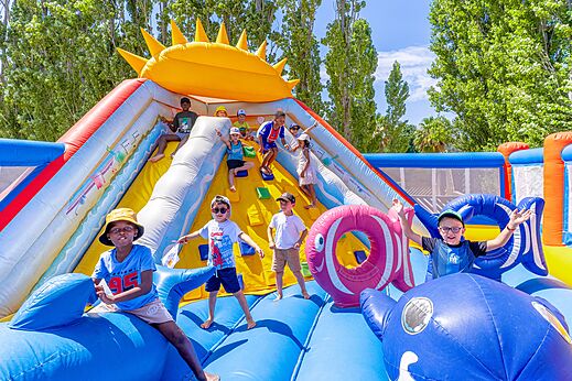 Enfants jouant sur un grand ch�teau gonflable avec toboggan au camping VAGUES OCEANES Au Flamenco � Argel�s-sur-Mer (66).