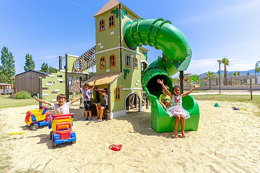 Aire de jeux avec toboggan et enfants souriants au camping VAGUES OCEANES Au Flamenco � Argel�s-sur-Mer (66).